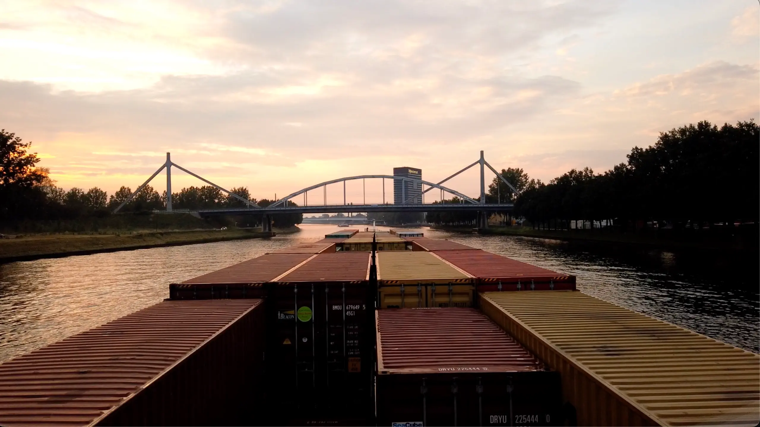 Uitzicht vanuit het stuurhuis van een containerschip op een kanaalbrug.